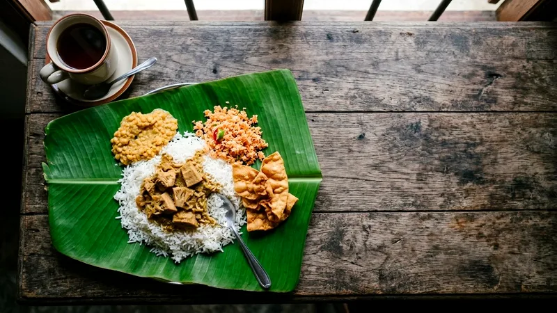 Sri Lankan rice and curry dishes on a banana leaf with tea.